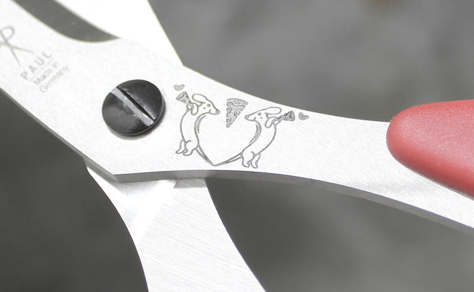 Detailansicht der PAUL Pizzaschere mit feiner Dackel-Gravur auf dem Halm und Schriftzug Made in Germany