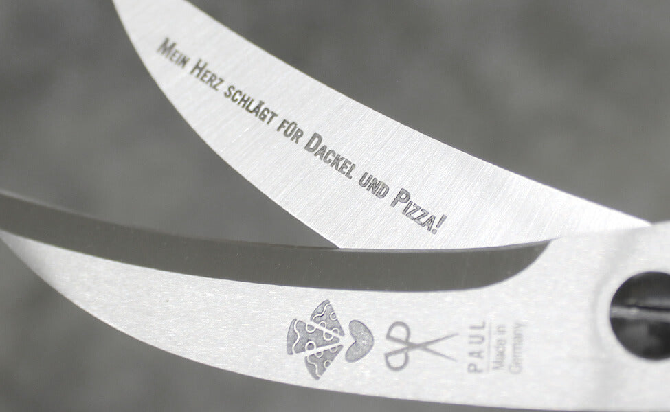 Detailansicht der PAUL Pizzaschere mit feiner Pizza- und Spruchgravur sowie dem Schriftzug „Made in Germany“.