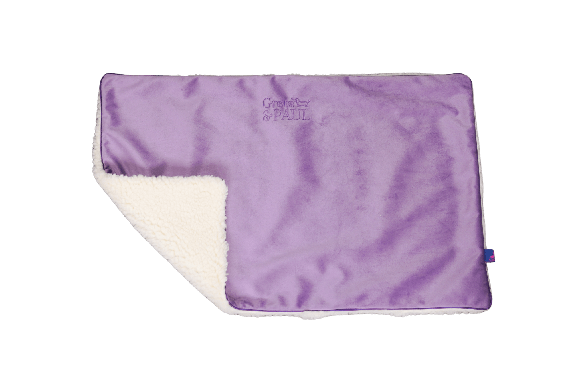 Premium-Hundedecke von Greta & PAUL in Flieder, die umgeschlagene Ecke zeigt das kuschelige, weiße Teddyfutter.