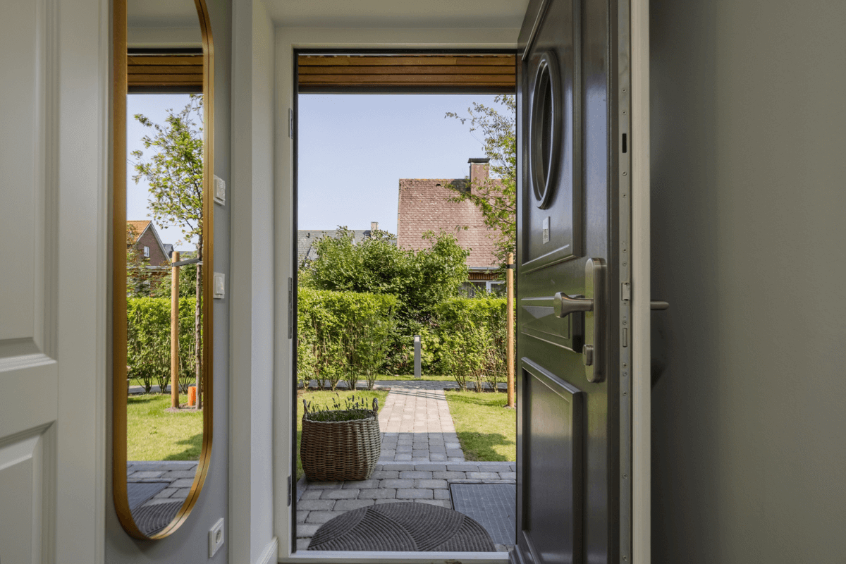 Einladender Eingangsbereich der Ferienwohnung 'Greta & Sylt' mit Blick durch die offene Tür in den Garten.