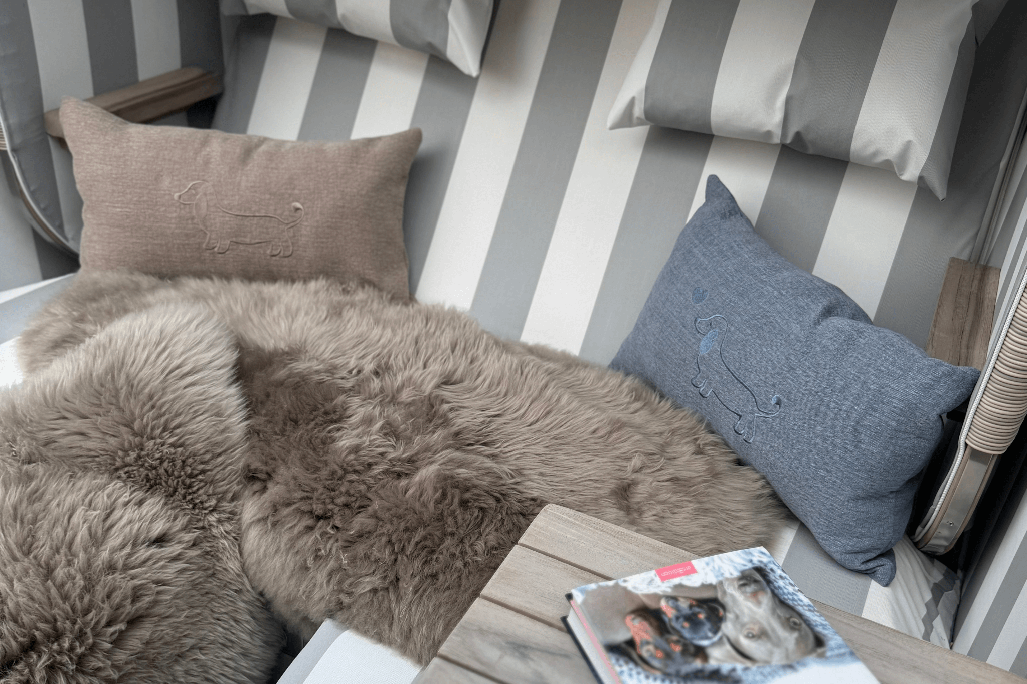 Eine maritime Szene: Leinen-Kissen von Greta & PAUL in Hellbeige und Hellblau schmücken einen gemütlichen Strandkorb.