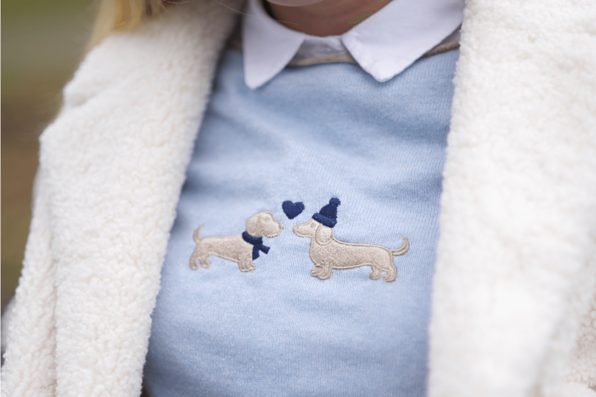 Detailaufnahme der Bestickung auf Gretas Dackelpullover in Hellblau