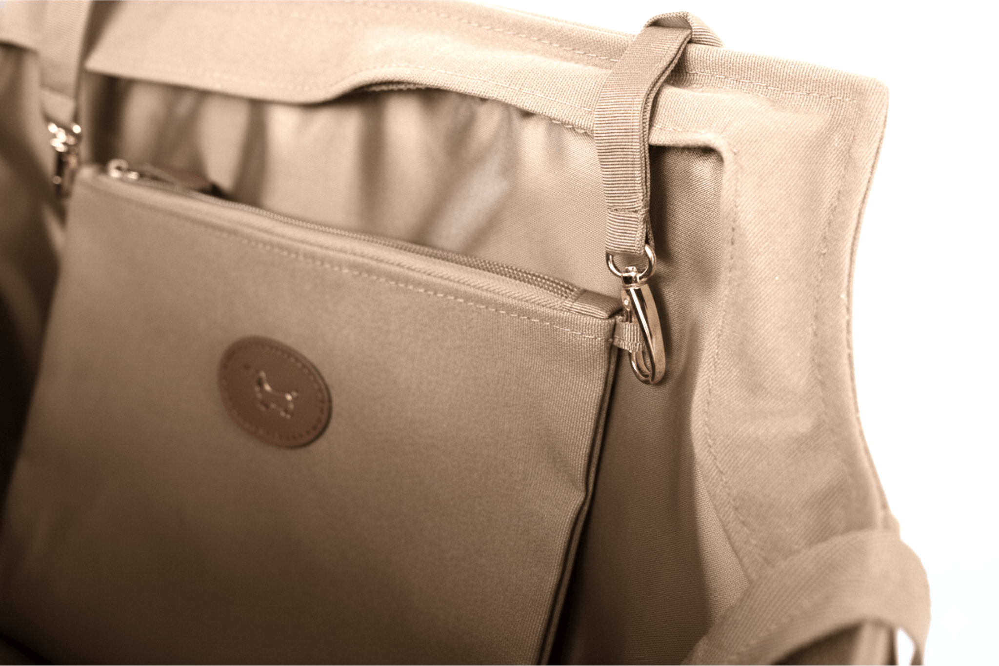 Nahaufnahme von Gretas Secret Täschchen in Cappuccino-Beige, die die Befestigung in Gretas Premium-Hundetasche zeigt