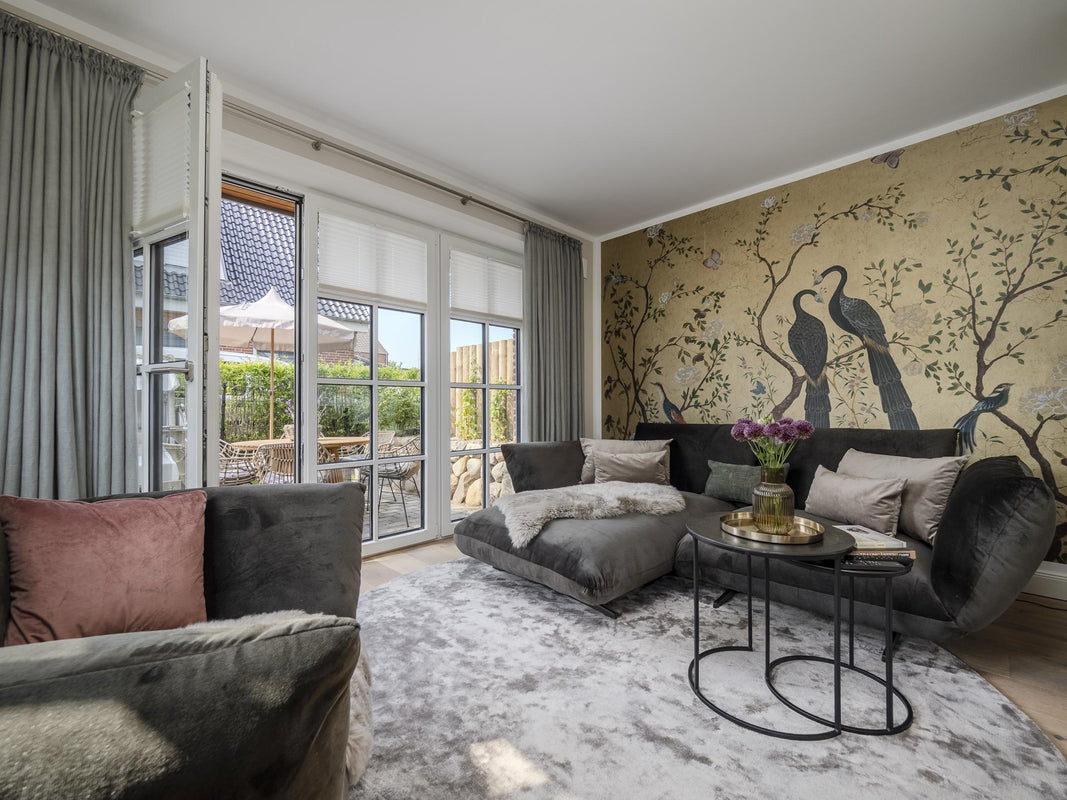 Einblick in das Appartement 'Greta & Sylt': das luxuriöse Wohnzimmer mit Designer-Tapete und Terrassenzugang.
