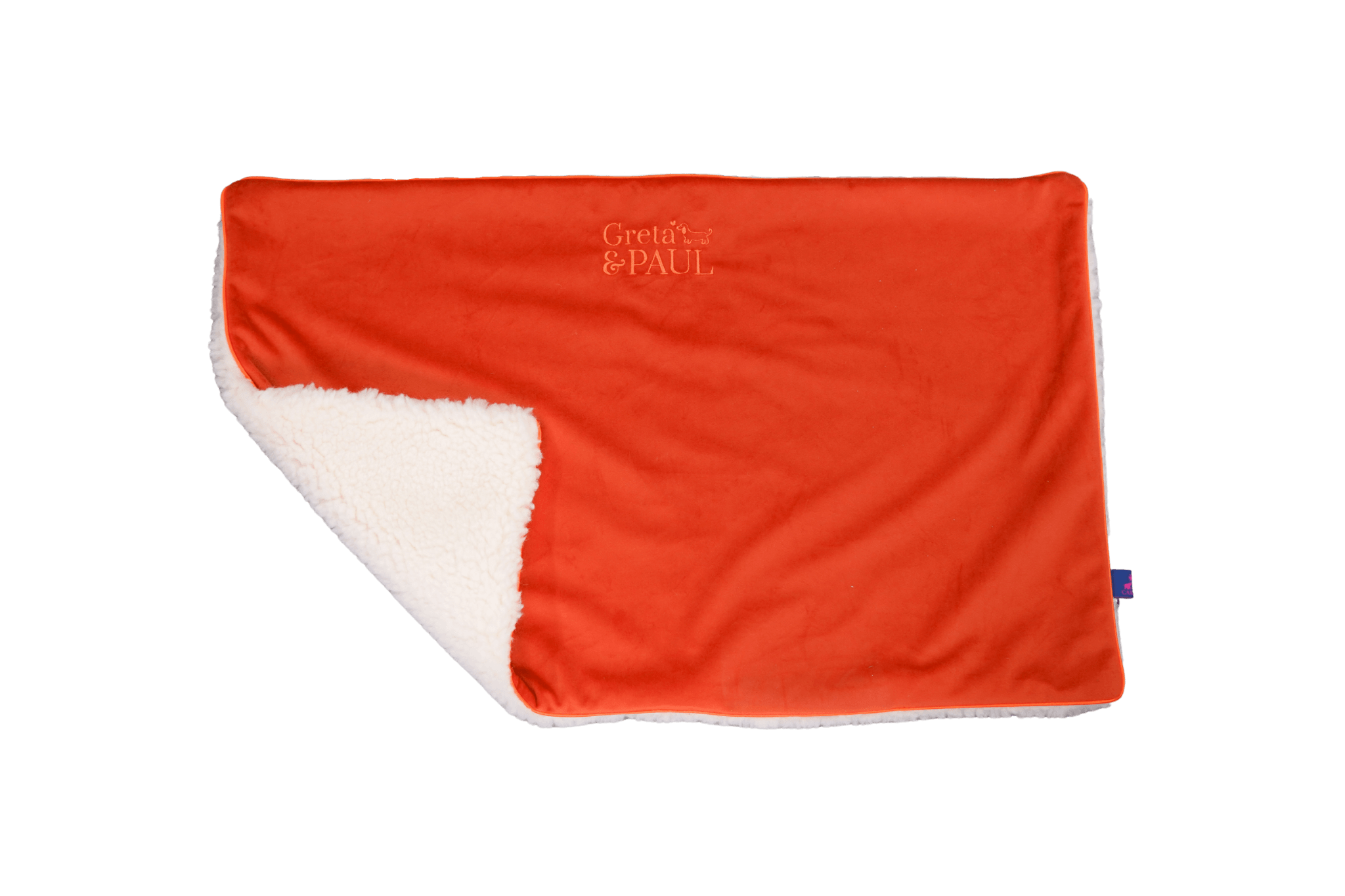 Premium-Hundedecke von Greta & PAUL in Orange, die umgeschlagene Ecke zeigt das kuschelige, weiße Teddyfutter.
