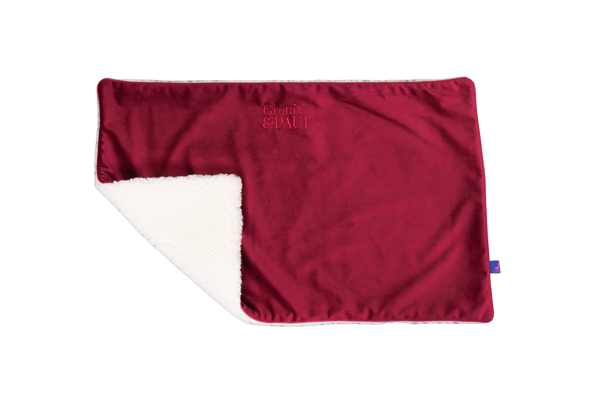 Premium-Hundedecke von Greta & PAUL in Very-Berry, die umgeschlagene Ecke zeigt das kuschelige, weiße Teddyfutter.
