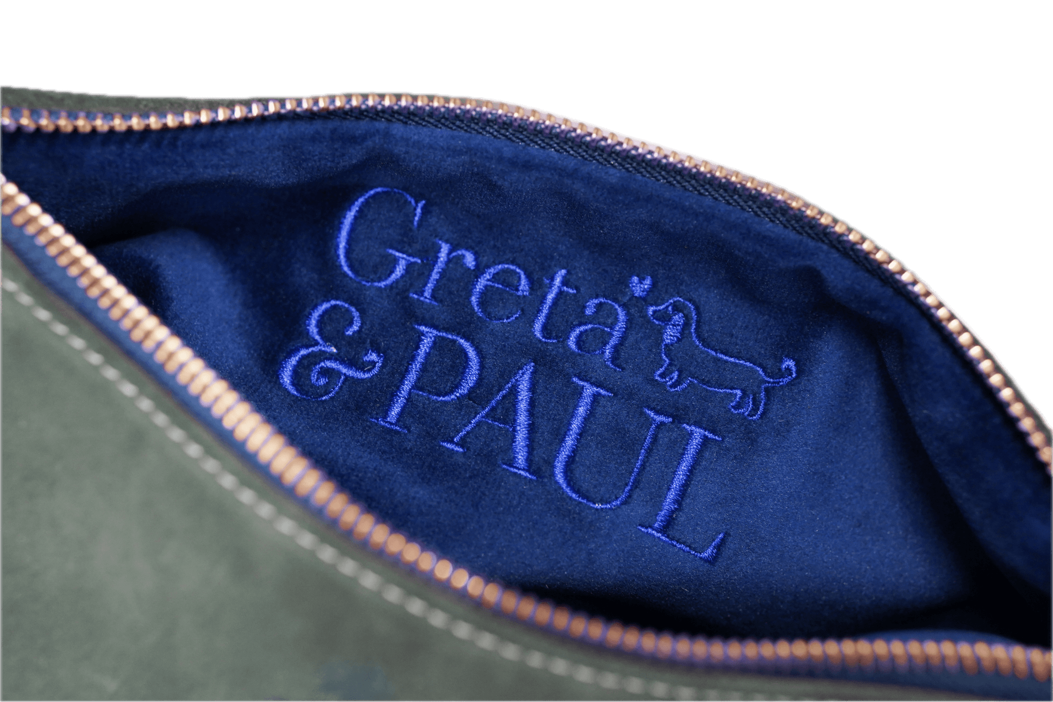 Detailaufnahme des königsblauen Innenfutters der Khaki Greta & PAUL Clutch 'Stella Deluxe' mit aufwendig gesticktem Logo