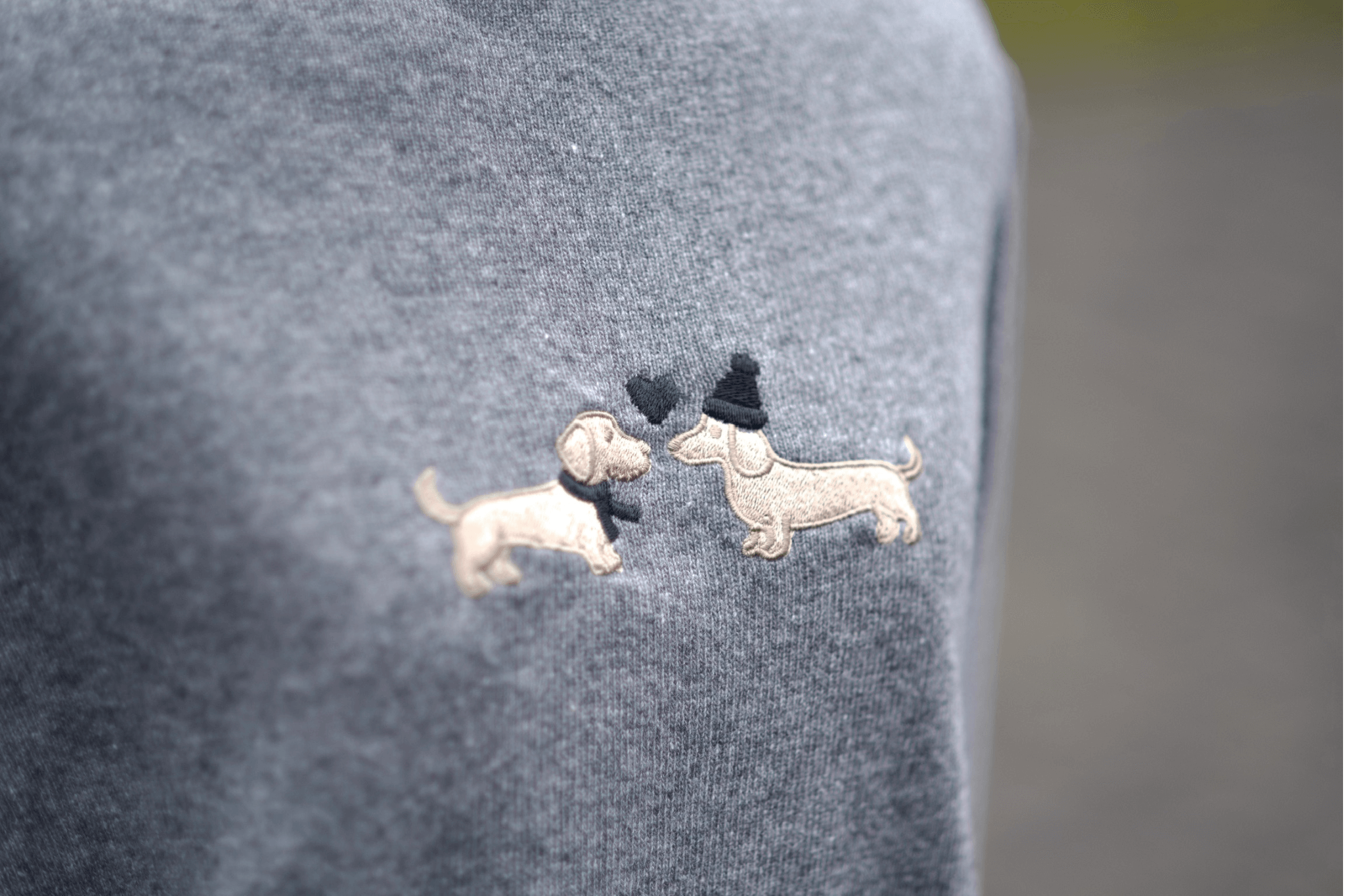 Detailaufnahme der Bestickung auf Gretas Dackelpullover in Grau