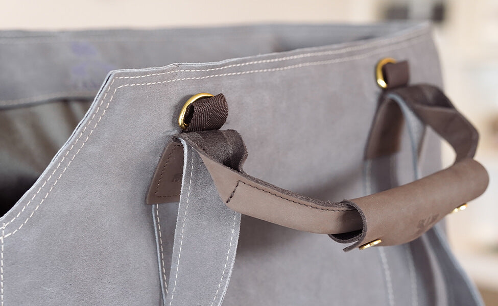 Detailaufnahme des Tragegriffs der grauen Wildledertasche von Greta & PAUL.